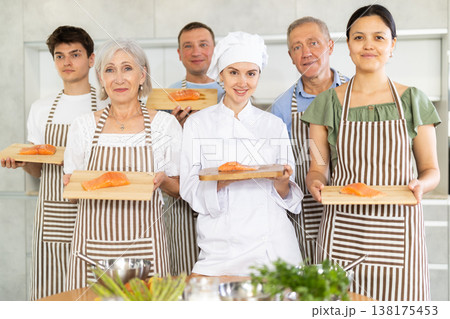 Smiling female chef posing along with cooking course participants 138175453