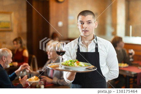 Guy waiter with tray in cafe hall Guy waiter with tray in cafe hall 138175464