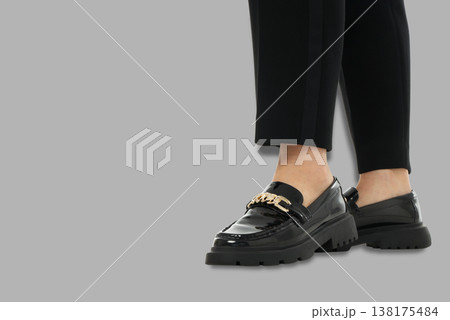 Young woman wears black shoes with a shiny finish 138175484