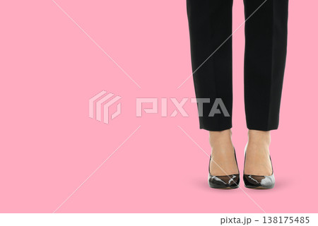Model in black pants and shoes on pink backdrop 138175485