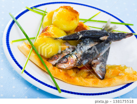 Dish of tasty fried sprats with fried potato croquettes and cake 138175518