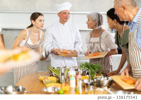 Positive chef sharing secrets of cooking salmon during culinary courses 138175541