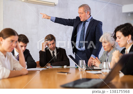 Portrait of angry male boss in business suit pointing to the door to his subordinate during meeting forcing him Portrait of angry male boss in business suit pointing to the door to his subordinate during meeting forcing him 138175568