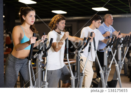 Young sporty girl working out on elliptical machine in gym 138175655