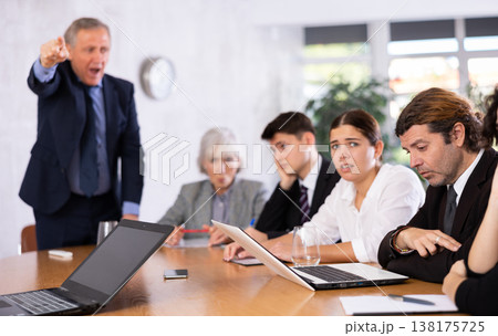 Angry male boss reprehending colleagues on meeting in office 138175725