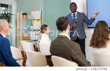 African man conducts training in front of businessmen African man conducts training in front of businessmen 138175768