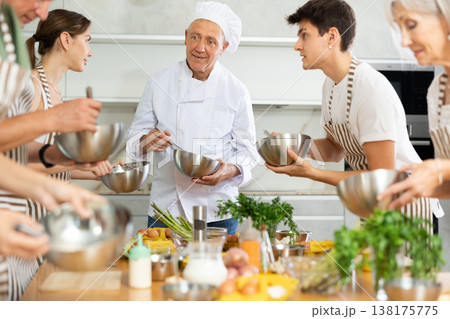 Elderly man teaching cooking to group of people Elderly man teaching cooking to group of people 138175775