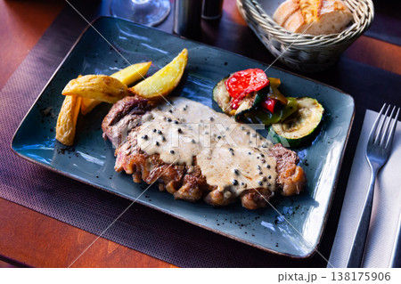 Veal steak with piquant creamy sauce, potatoes and vegetables Veal steak with piquant creamy sauce, potatoes and vegetables 138175906
