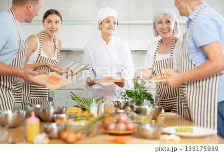 Asian woman chef sharing secrets of cooking salmon at culinary class Asian woman chef sharing secrets of cooking salmon at culinary class 138175939