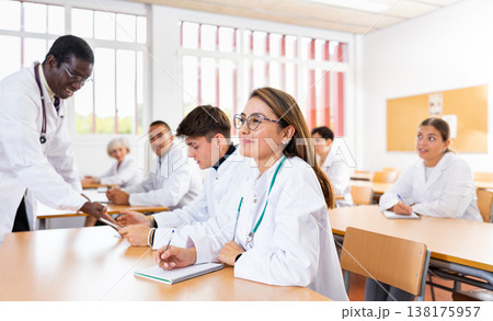 Young hispanic female medical student taking notes during group lecture Young hispanic female medical student taking notes during group lecture 138175957