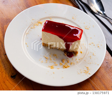 Slice of delicious classical cheesecake with fruity sauce served in cafeteria 138175971