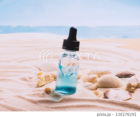 Glass bottle with serum gel cosmetic product with air bubbles on the background of seashells and sea beach sand. product presentation on a sandy background Glass bottle with serum gel cosmetic product with air bubbles on the background of seashells and sea beach sand. product presentation on a sandy background 138176291