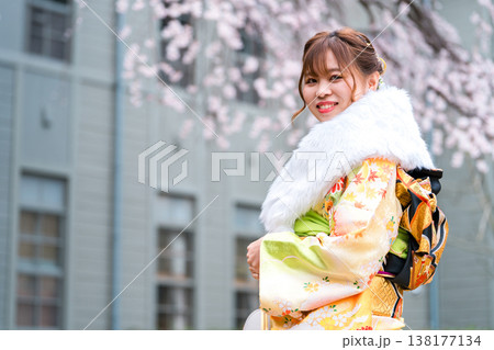 桜の木下で振袖の着物を着る成人式,二十歳の集いを迎える日本人女性 138177134