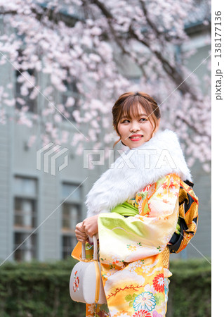 桜の木下で振袖の着物を着る成人式,二十歳の集いを迎える日本人女性 138177136