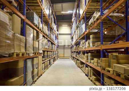 Warehouse aisle between high shelves stocked with boxes for inventory control 138177206