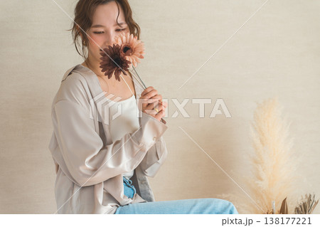 一輪のガーベラの花を持つ女性 138177221