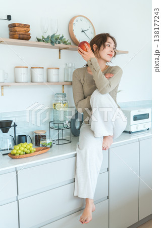 キッチンでりんごを食べる女性(ダイエット,ベジタリアン) キッチンでりんごを食べる女性(ダイエット,ベジタリアン) 138177243