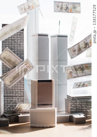 Hundred dollar bills rain down on a miniature city skyline, symbolizing financial success and urban wealth Hundred dollar bills rain down on a miniature city skyline, symbolizing financial success and urban wealth 138177529