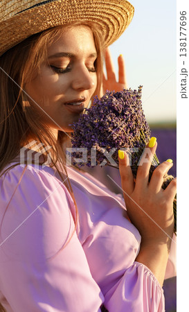 Woman holds lavender bouquet in a field during sunset Woman holds lavender bouquet in a field during sunset 138177696