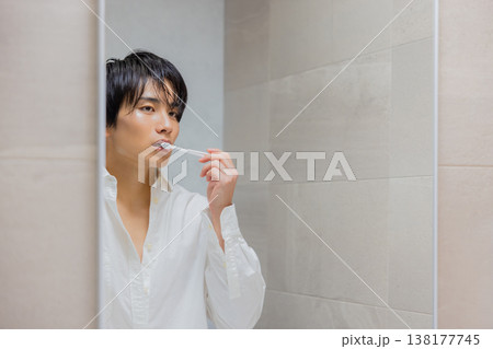 洗面所で歯磨きをする男性 138177745