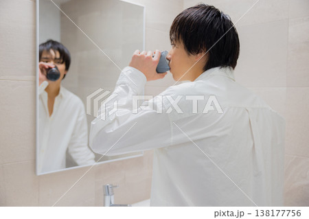 洗面所で歯磨きをする男性 138177756