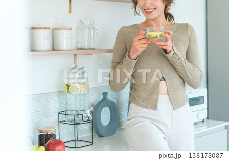 キッチンカウンターでデトックスウォーターを飲む女性 キッチンカウンターでデトックスウォーターを飲む女性 138178087