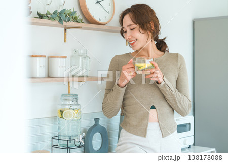 キッチンカウンターでデトックスウォーターを飲む女性 キッチンカウンターでデトックスウォーターを飲む女性 138178088