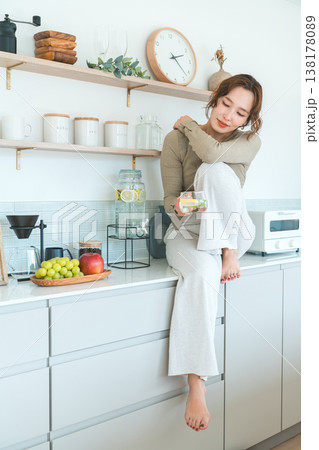 キッチンカウンターでデトックスウォーターを飲む女性 キッチンカウンターでデトックスウォーターを飲む女性 138178089