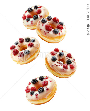 Multiple glazed donuts topped with blueberries and raspberries, on white background. Concept of sweet food and dessert pattern 138179153