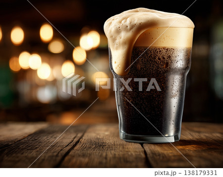 Frothy stout beer tall glass on a rustic wooden bar background, representing refreshment and rich beverage appeal Frothy stout beer tall glass on a rustic wooden bar background, representing refreshment and rich beverage appeal 138179331