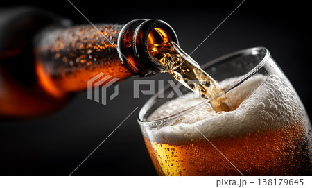 Fizzy dark stout beer being poured into chilled glass on warm brown background, concept of refreshment and taste Fizzy dark stout beer being poured into chilled glass on warm brown background, concept of refreshment and taste 138179645