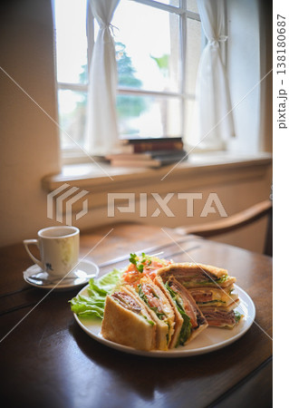 テーブルに置かれたサンドイッチとコーヒーのモーニング 138180687