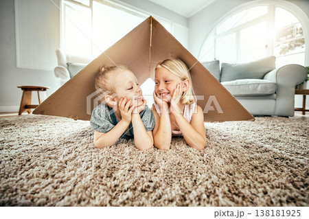 Smile, kids and cardboard for insurance with girl sisters on the floor of the living room at home. Security. family or children and young siblings on a carpet in their house for safety with flare 138181925