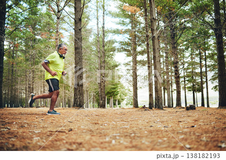 Senior man, fitness and running in forest for workout, outdoor exercise or cardio training in nature. Mature and active male person, athlete or runner in woods with trees for trekking and hiking 138182193