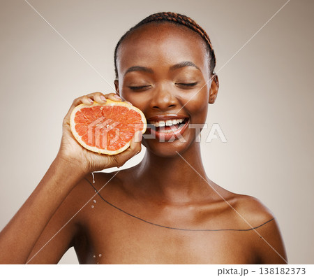 Portrait, smile or happy black woman with grapefruit for skincare or beauty in studio on brown background. Results, dermatology or African person with natural fruits, vitamin c or glow for wellness Portrait, smile or happy black woman with grapefruit for skincare or beauty in studio on brown background. Results, dermatology or African person with natural fruits, vitamin c or glow for wellness 138182373