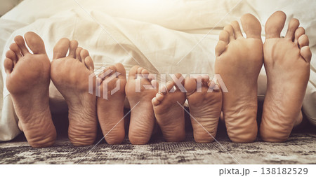 Feet, love and family in bed together to relax on a weekend morning in their home with flare. Mother, father and children with blankets sleeping in the bedroom to rest while dreaming closeup 138182529