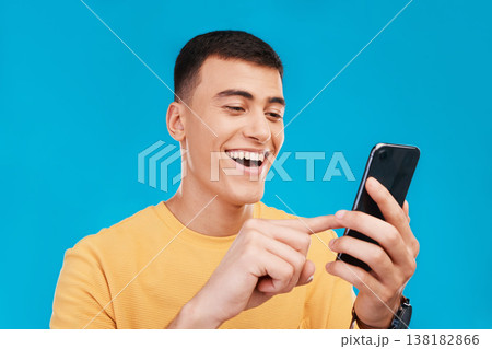 Phone, excited and young man in a studio scroll on social media, mobile app or the internet. Smile, happy and male person from Canada networking on website with cellphone isolated by blue background. Phone, excited and young man in a studio scroll on social media, mobile app or the internet. Smile, happy and male person from Canada networking on website with cellphone isolated by blue background. 138182866