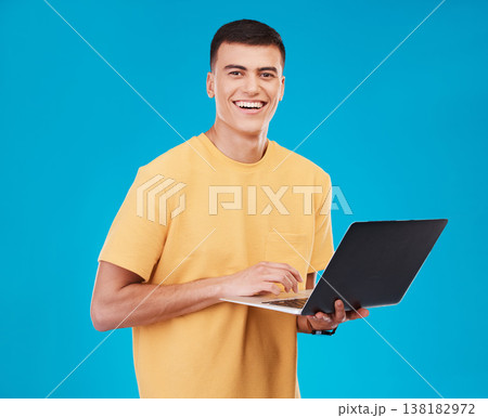 Portrait, happy man or student with laptop in studio on blue background with mockup for e learning. Male model, person and smile with technology, typing or respond to email by online and work on web 138182972