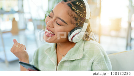 Phone, dance and happy woman on music headphones in home living room. Smartphone, radio and excited African person listening to podcast, audio and sound for freedom, celebration and streaming online 138183286