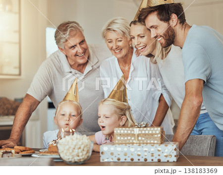 Parents, grandparents and children at birthday with cake in celebration with sweets, love and gift in home. Happiness, men and women together at table at kids party in house with girl blowing candles 138183369