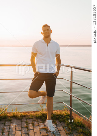 Stylish Man In White Polo Relaxing By Waterfront 138183657