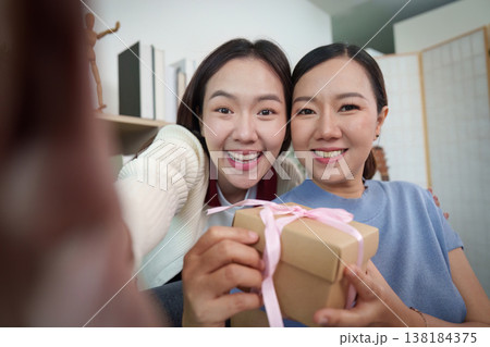 Mother and daughter exchanging a gift with joy 138184375