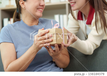 Mother receiving a heartfelt gift from her daughter 138184379