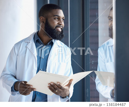 Doctor, black man and thinking of healthcare information, paperwork or documents by window in building with smile. Person, professional or person thoughtful of notes or charts on paper with ideas 138184487
