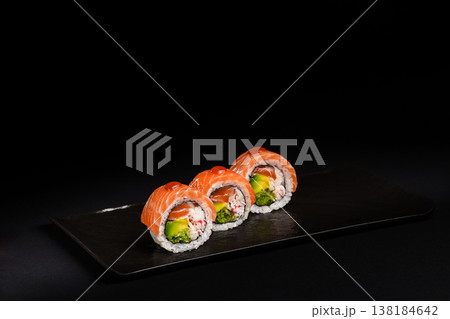 Delicious Fresh Salmon Sushi Rolls Presenting Exquisitely on a Black Background Delicious Fresh Salmon Sushi Rolls Presenting Exquisitely on a Black Background 138184642
