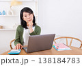 パソコンと電卓を使って悩む50代主婦 138184783