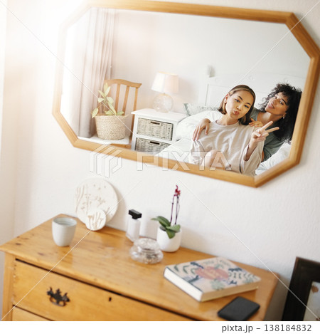 Happy lesbian couple in bedroom with mirror, peace sign icon and relax together in apartment. Queer love, smile and reflection of lgbt women on bed with emoji hand gesture, trust and support in home. Happy lesbian couple in bedroom with mirror, peace sign icon and relax together in apartment. Queer love, smile and reflection of lgbt women on bed with emoji hand gesture, trust and support in home. 138184832