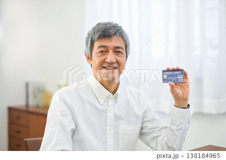 リビングでカードを見る60代の男性 138184965