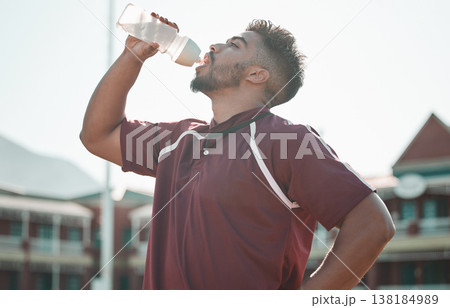Football player, drink water and rest on sports field for training completion, workout and exercise outdoors. Fitness, workout and male athlete with liquid bottle for wellness, hydration or practice Football player, drink water and rest on sports field for training completion, workout and exercise outdoors. Fitness, workout and male athlete with liquid bottle for wellness, hydration or practice 138184989