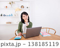 パソコンと電卓を使いながら悩む50代女性 138185119